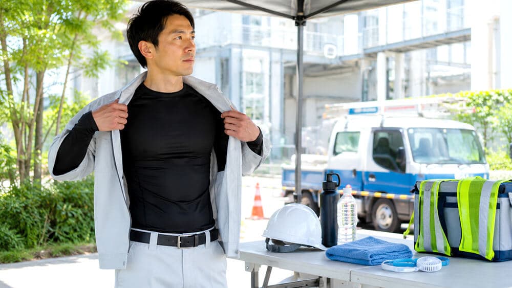 屋外作業で冷感インナーや暑さ対策用品を身につける作業者のイメージ