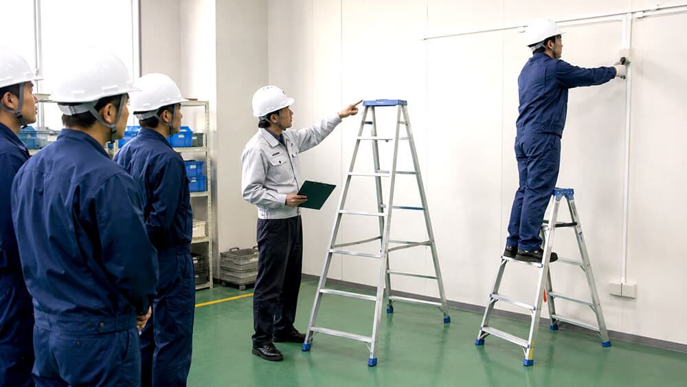 はしごと脚立の違いを確認する日本の倉庫・工場担当者