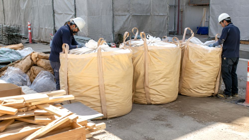 建設現場で廃材を入れる大きい袋を準備するイメージ