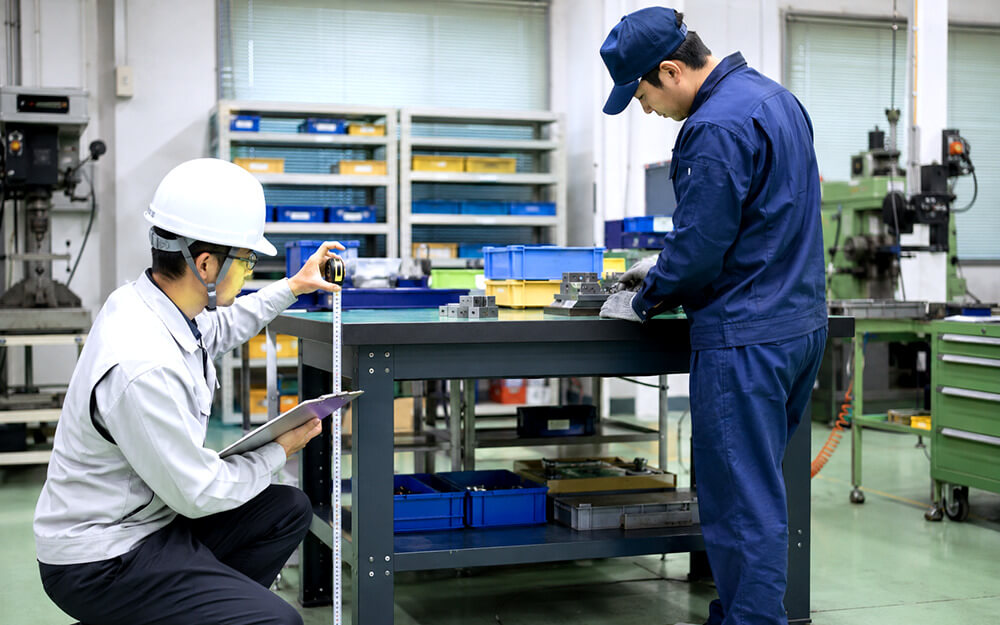 作業台の高さと姿勢を確認する工場担当者